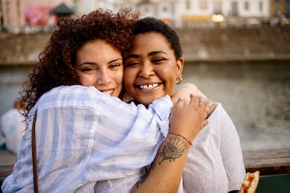 two women smiling and embracing as they chat about virgo compatibility